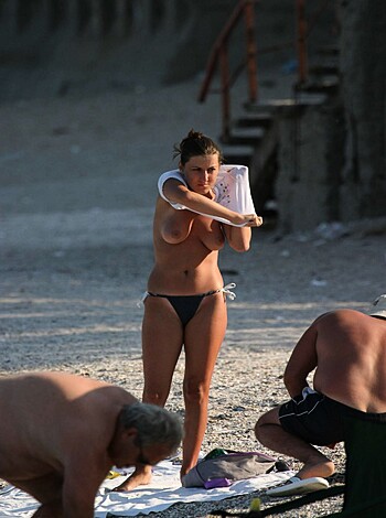 Here's the fuckin' picture of some hot-ass bitch standin' at the damn beach wit' a towel draped over them tits and shit, hands on them fuckin' hips.