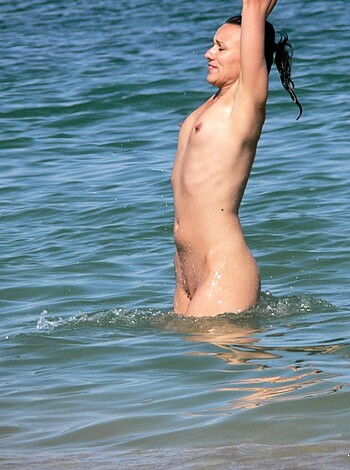 This bitch ain't wearing no fucking top or bra as she's jumping into the goddamn ocean with her hands in the air like a dumb cunt!