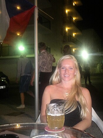 Vulgar description: Look at this fucking slut with her tits hanging out of that tight-ass black dress she's wearing, her smile all fake as she sips on some goddamn beer like it doesn't give a shit.