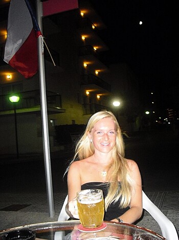 "Smiling blonde bimbo with a brew between her tits."