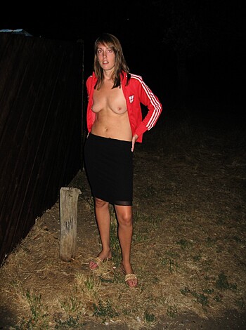 "Here's a fuckin' picture of some chick showin' off her tits in a skirt, standin' outside at night with one hand on her hip."
