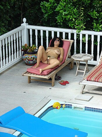 "Here's a shot of some bikini-clad broad sunbathing by the pool, with her tits and pussy hanging out for all to see."