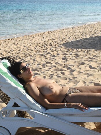 Here's a fucking picture of some chick loungin' topless on a beach chair with her top bitch ass cheeks covered by a pair of bikini bottoms.