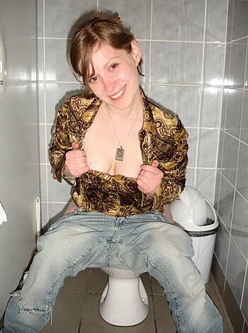 Vulgar description: This image shows a fucking hot chick with her tits hanging out, sitting on the crapper like some kind of goddamn porno queen.