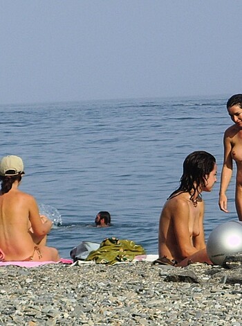 A bunch of fucking sluts at the beach, one with her tits out, the others in bikinis. They're chilling on some fucking towels while checking out some ocean views.