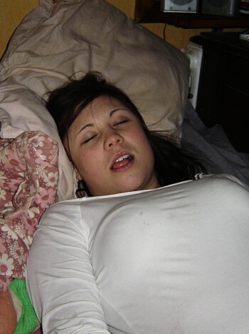 A naked chick lies peacefully on her bed with her face smushed into the pillow, sporting a tight bra and panties.