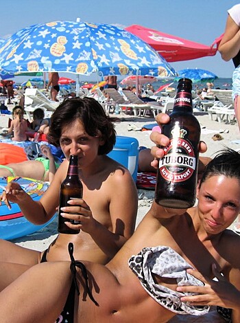 Two bare-titted bitches chugging brews on the sand.