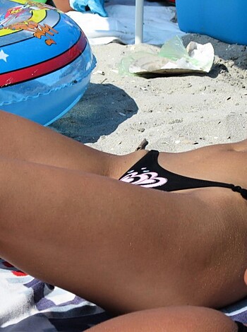 "Check out this f*cking chick in her skimpy bikini, lying on her back on the sandy shore, her tits jiggling and her pussy dripping wet."