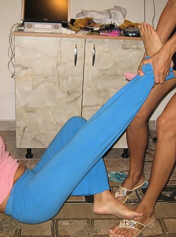 Two chicks are rubbing their toes together while laughing.