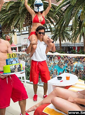 Vulgar description:
Check out this shirtless chick baking with some dude while flipping off the camera, bro.