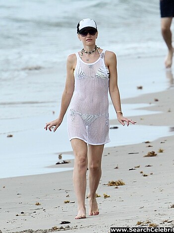 A hot, sexy babe struts her tight ass down the sandy shore while showing off her juicy tits and pussy through her nearly transparent swimming attire.