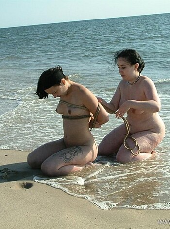Two naked broads chillin' on the sandy shore at sundown, with their legs spread wide and their pussies gaping open for all to see.