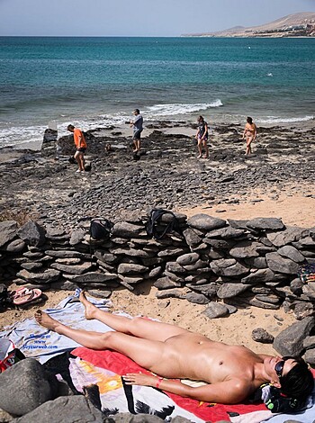 Here's a caption for you:
"Naked dick dangle on a beach towel."