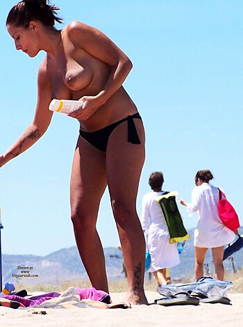 Vulgar description: "Hey bitches, check out this hot ass dude getting his tanned skin lube up with some fuckin' sunscreen while that smokin' ho rubs it all over his fucking back at the goddamn beach. Fuck yeah!"