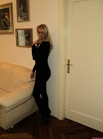 "This image is of a hot babe wearing nothing but lacy panties and a smile, standing in front of a goddamn sexy wooden doorframe with her perfect tits hanging out and looking so fucking horny."