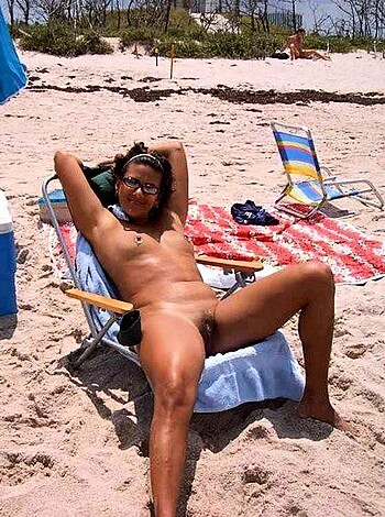 A hairy, tattooed fucker chillin' on a beach towel with his junk hanging out.