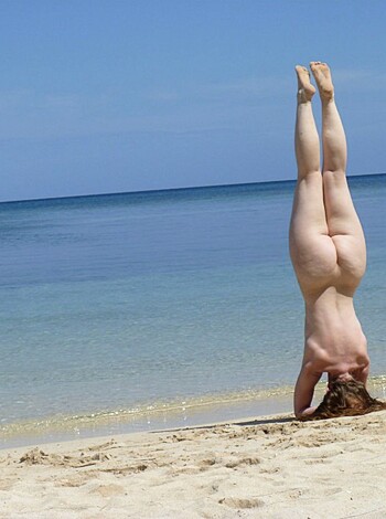 "F*cking hot bitch bends over sand, showing off toned ass."