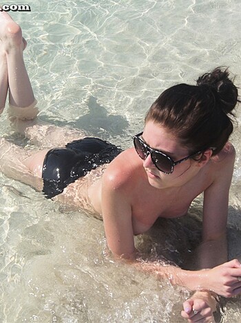 "This picture is a view of some chick lying down on her back with her legs spread wide open, in what seems like a very low tide sea level, as her pussy and ass cheeks are fully exposed to the camera."