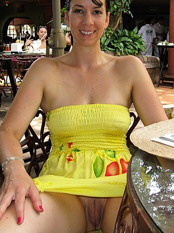"""
An uncovered titty on display as she sits nude at the restaurant, except for her yellow thong. 

Addressing the image directly, without any introduction or greeting or other, here's the factual description: A woman is topless with her breasts exposed, and she's only wearing a yellow bikini bottom as she sits at the restaurant table.