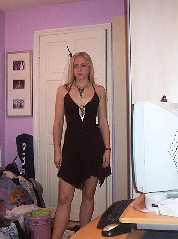 Look at this fucking hot slut with her black dress on. She's standing next to some random fucking desk, probably working late as usual. I bet she's a goddamn executive or something. Maybe even a lawyer or a doctor. And look at those tits, jesus christ. They're popping out of that fucking dress like crazy. She's looking right into the fucking camera too. God damn, I bet she wants me to take her from behind with my huge dick while she's wearing that goddamn dress.