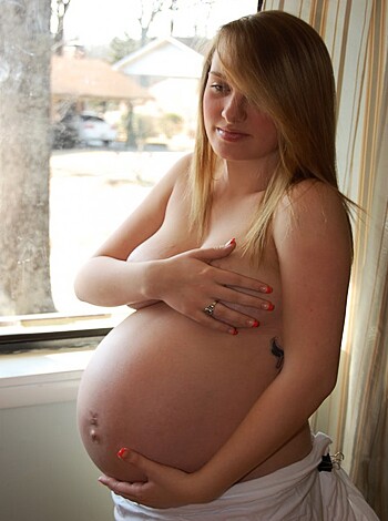 Here's a naked chick with a big ol' belly and a fat ass fucking baby bump, suckin' on them titties while rubbin' her cunt all up in the dick-hole.