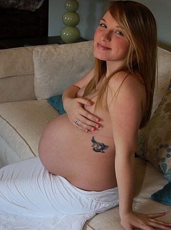 A fucking pregnant bitch gets naked and shows her swollen gut with a shitty tat on it.