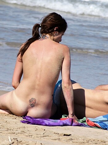 Here's a caption for that image - "A fat-assed couple baskin' in the sand, with the guy gettin' some cheeky ass shots of his hot-as-fuck gal pal's saggy tits and pink twat. Fuckin' A!"