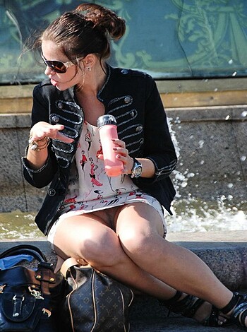 A bitch sits her hot ass on a wooden bench, showing off her short denim skirt and smooth legs.