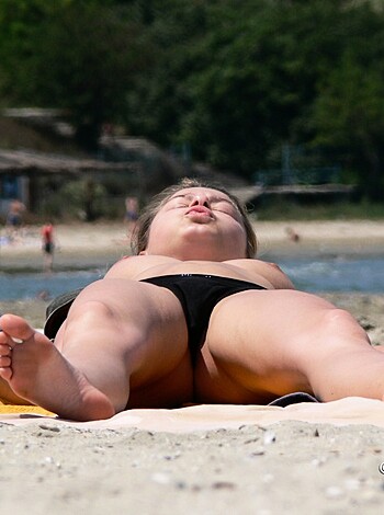 This photo shows a bitch's uncovered sticks and ass-cheeks sprawled out on a fuckin' beach blanket.