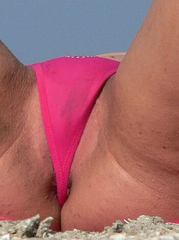 A close-up of a female ass with her red thong on display for all to see.