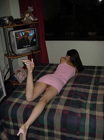 This chick is dressed to fuck in her pink frock and stilettos, laying on the bed like a slut waiting for some dick to penetrate that tight ass of hers.