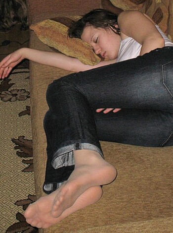 This bitch is chillin', got her jeans on and kicking it on the couch, with her ho-feet showing.