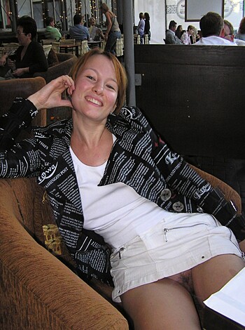 A bitch is sitting on a chair with her panty-ass cheeks hanging out, giving the camera a good look at her tight ass-crack thong.