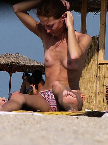 Vulgar Description: This picture shows a titty bitch sucking on her kid's nipple while sunbathing on the beach with some sand up her snatch and salty sea water dripping out of her twat.