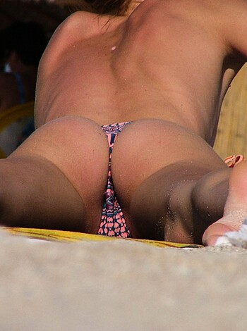 """
Close-up view of a pisshole of some hot babe with her ass cheeks hanging out of her swimsuit, probably on the beach.
"""