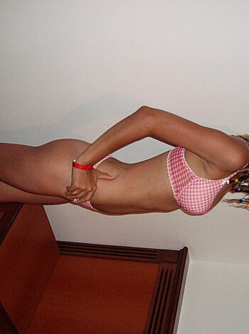 A hot chick stands stark naked in her bedroom, showing off her firm ass and tits.