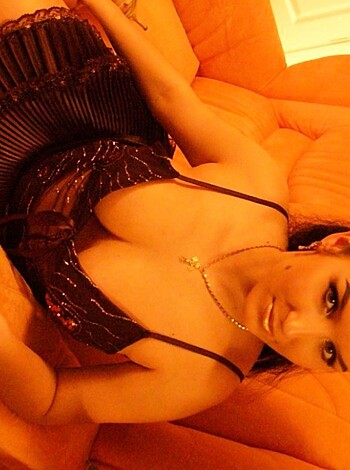 This bitch is dressed in sexy underwear and sitting her fat ass on the couch while staring intensely at the camera.