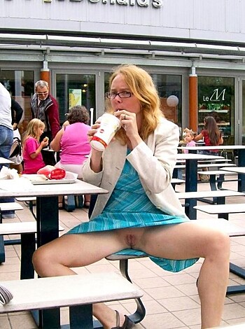 A hot chick is showing off her pussy on a park bench.