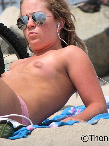 Vulgar Description:
"Here's a naked chick in her birthday suit, tanning out on a towel with some shades on and headphones blastin'."