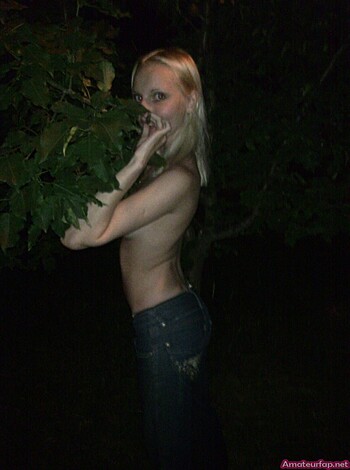 Blonde bitch is standin' behind foliage, ass towards the fuckin' camera.
