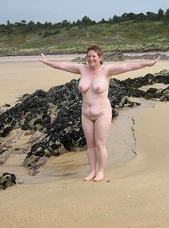 The fuckin' bitch is standing fuckin' naked on a fuckin' sandy beach, with her fuckin' feet in the fuckin' sand, and she's got her fat ass huggin' nature's fuckin' beauty like some kinda goddamn idiot.