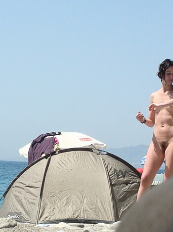 Look at this hot bitch standing nude on the sand, her hands extended towards the ocean as if she's gonna do some sort of ritual or something.