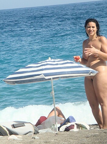 "Here's a naked bitch standin' on some sand with her tits out by the water."