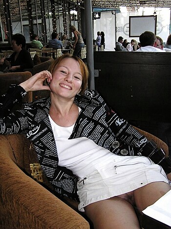 """
Hot chick in white top and short skirt, leg spread on couch, finger on pussy.
"""