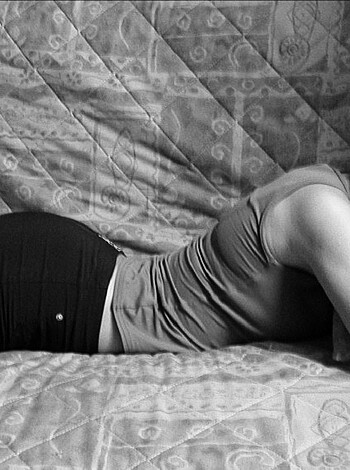 A chick lies naked as f*ck on her bed, her ass up in the air, waiting to get f*cked hard.