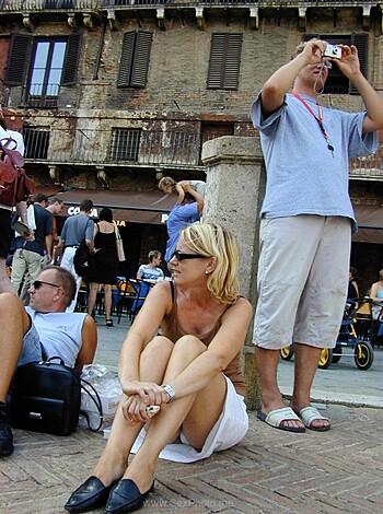 "Here's a photo of some dude taking a pic of his busty, bare-chested chick friend, who's sittin' on her ass."