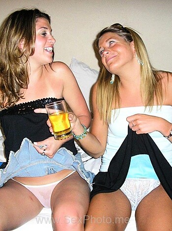 Two chicks getting wasted on a mattress, grinning like idiots with booze.