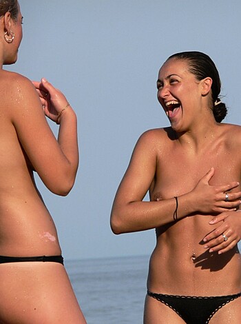 A couple tits hanging out by the shore, cackling away while they tan their nipples, chatting it up like there's no tomorrow.