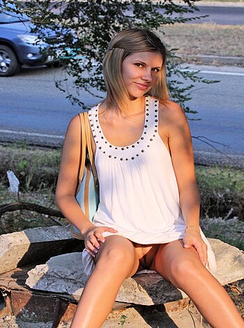 A hot, fit babe is flashing her tits and ass while chillin' on a park bench.