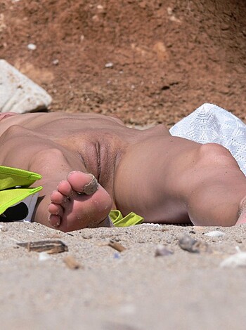 This fuckin' image shows a goddamn naked kid with his fuckin' ass on some yellow-assed beach blanket.